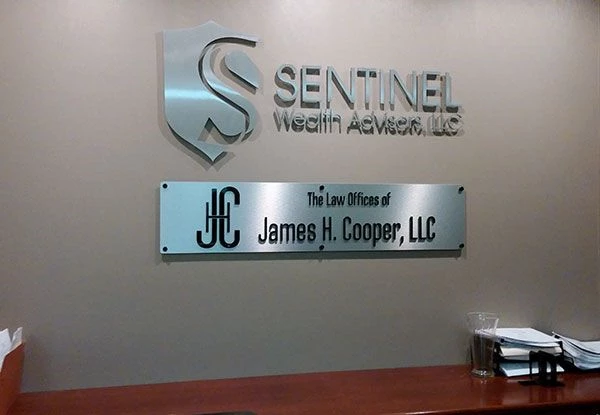 Interior Brushed Aluminum Dimensional Logos w/ Standoffs for Sentinel Wealth Advisors and the Law Offices of James H. Cooper in Kansas City, MO